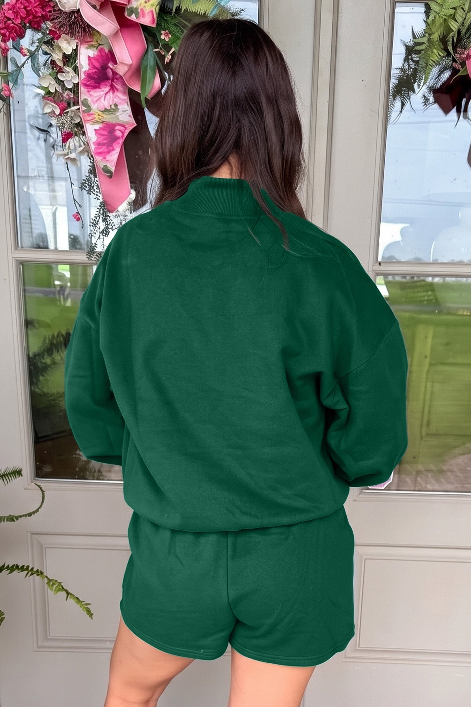 Back view of dark green mock neck sweatshirt and shorts set