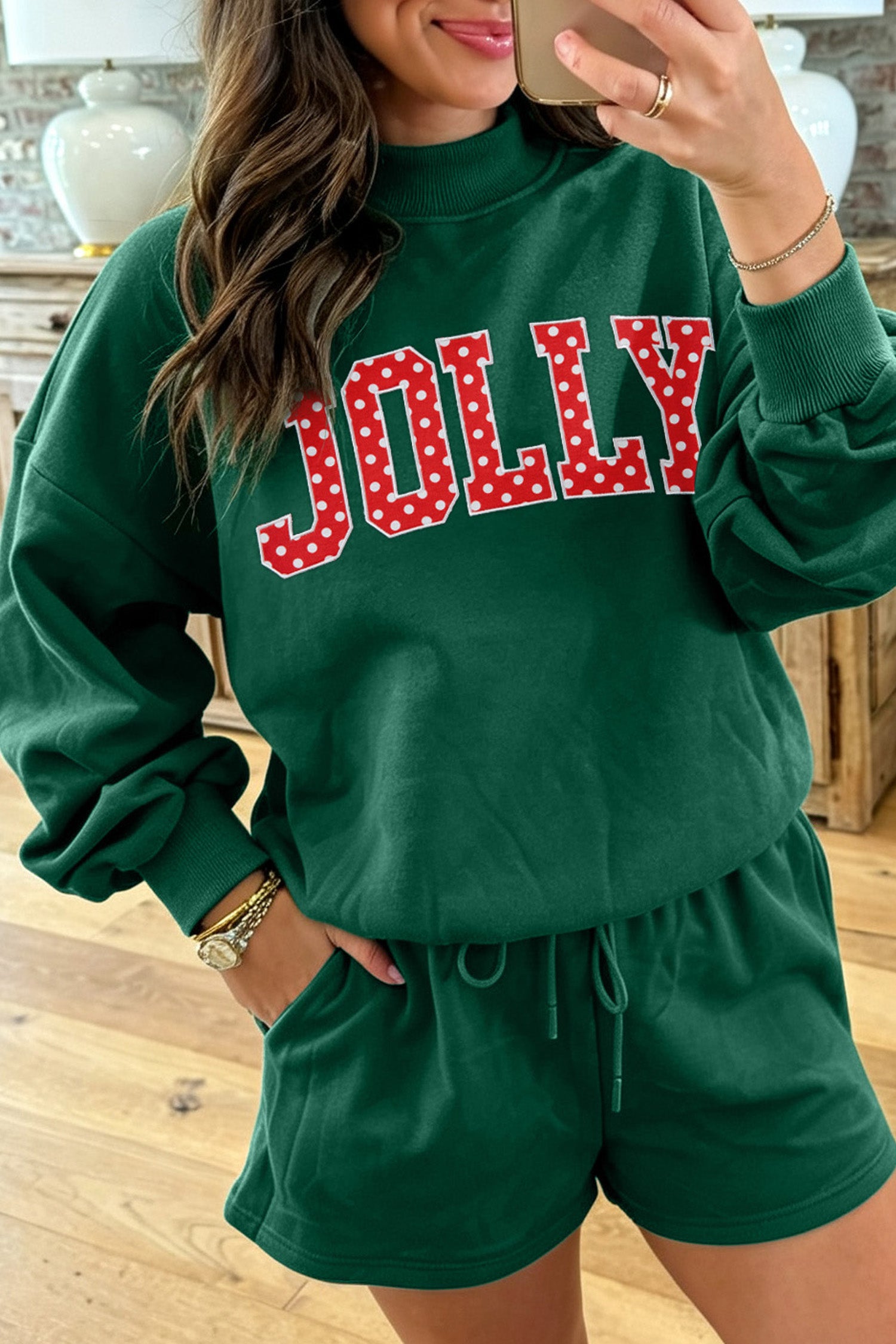 Woman in dark green JOLLY letter patch sweatshirt and shorts set, mirror selfie