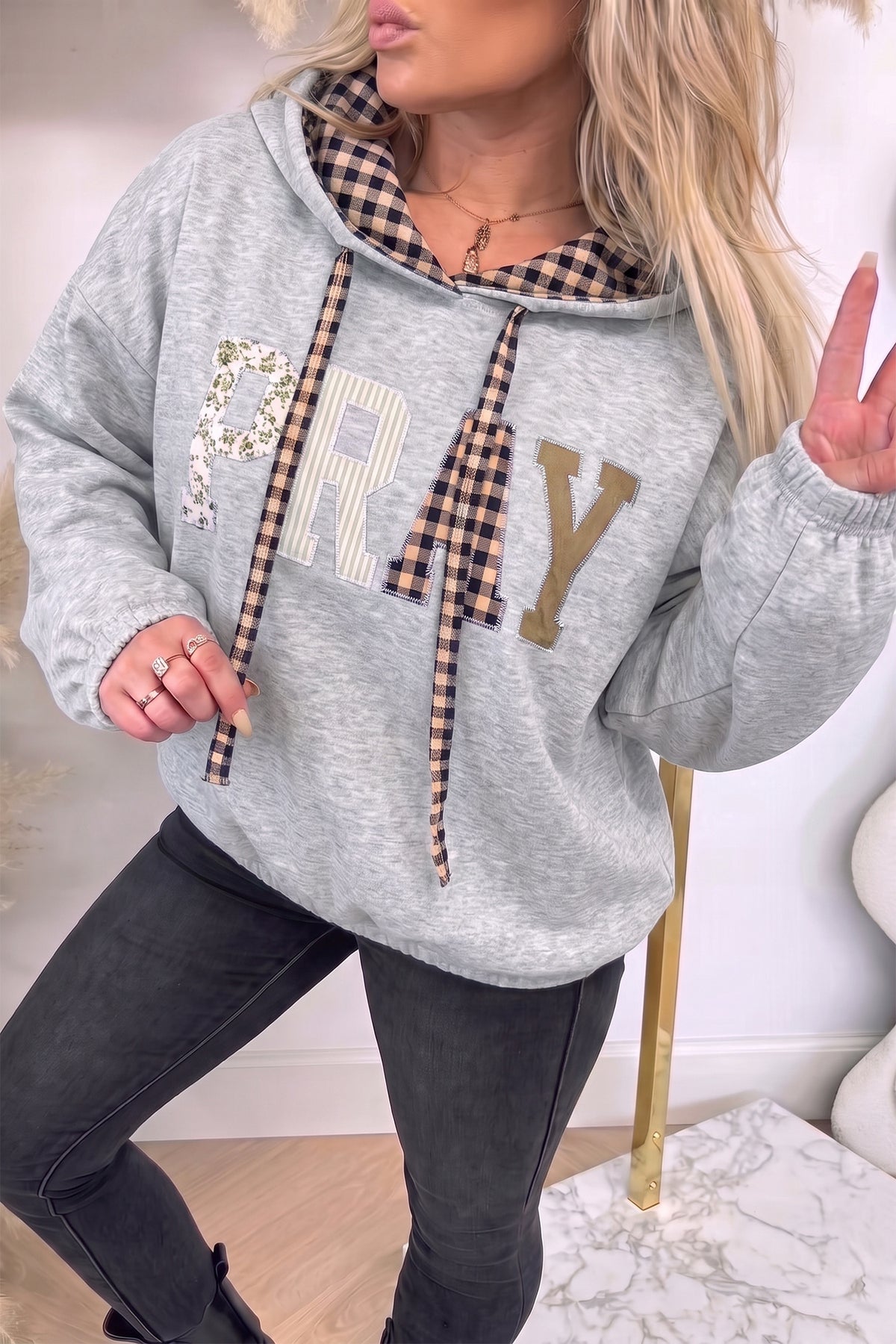 Light grey PRAY letter graphic hoodie with plaid hood lining and drawstrings, front