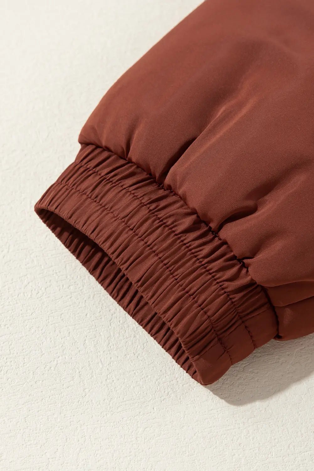 Close-up of a brown fabric with a textured edge on a beige background