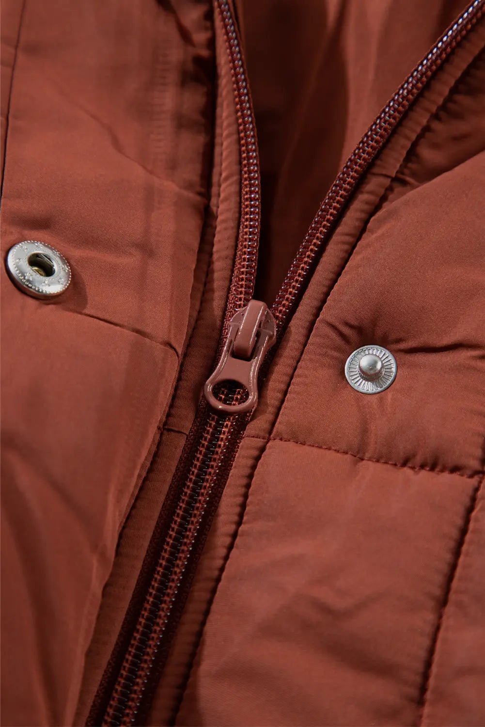 Close-up of a brown jacket with zipper and buttons