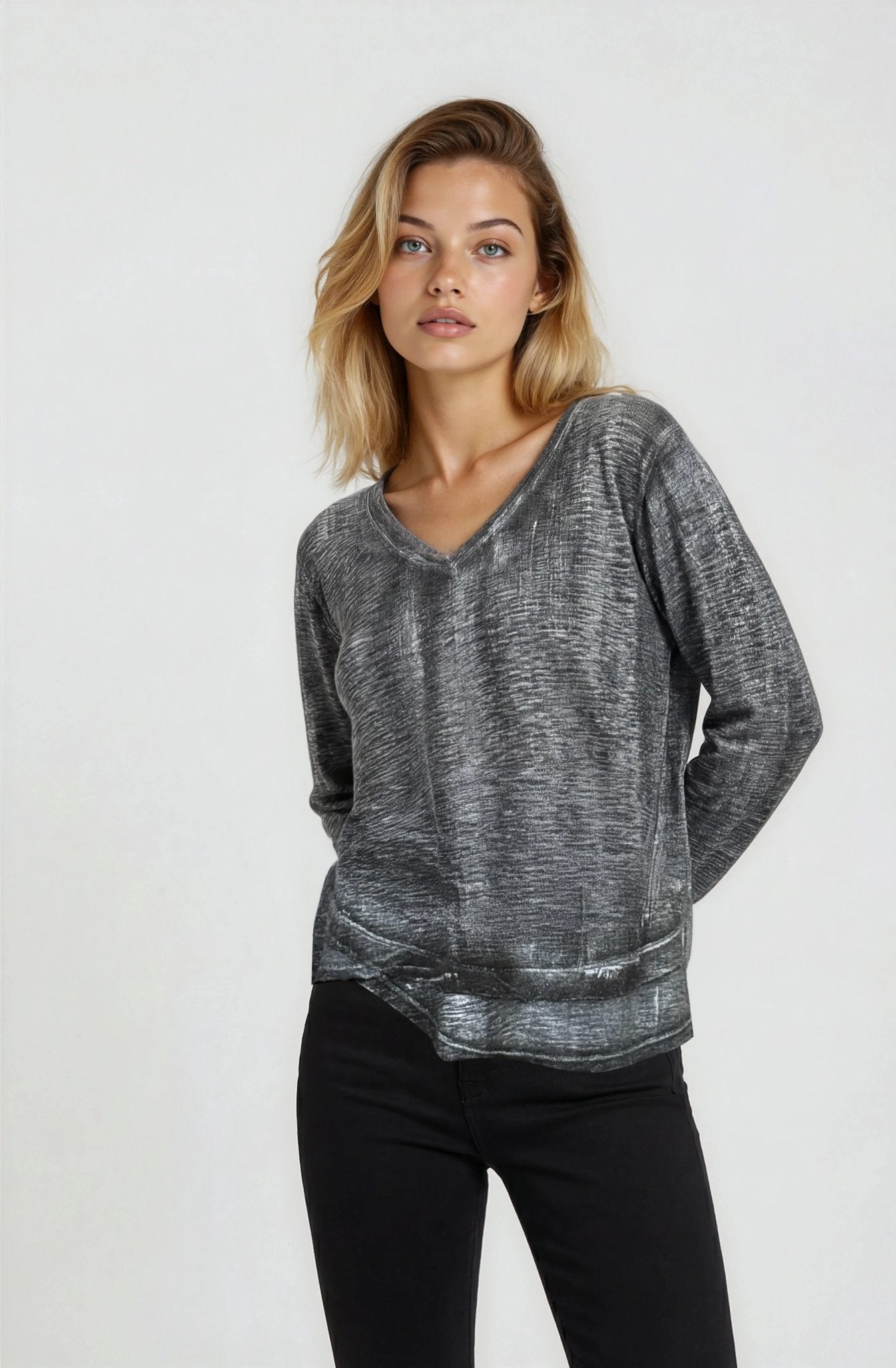 Woman wearing a gray sweater and black pants on a white background