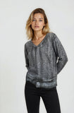 Woman wearing a gray sweater and black pants on a white background