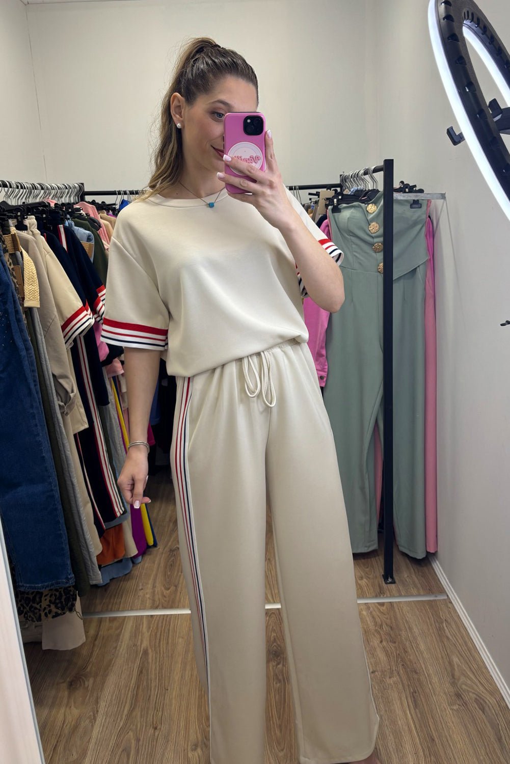 Person wearing a beige outfit with stripes in a clothing store.