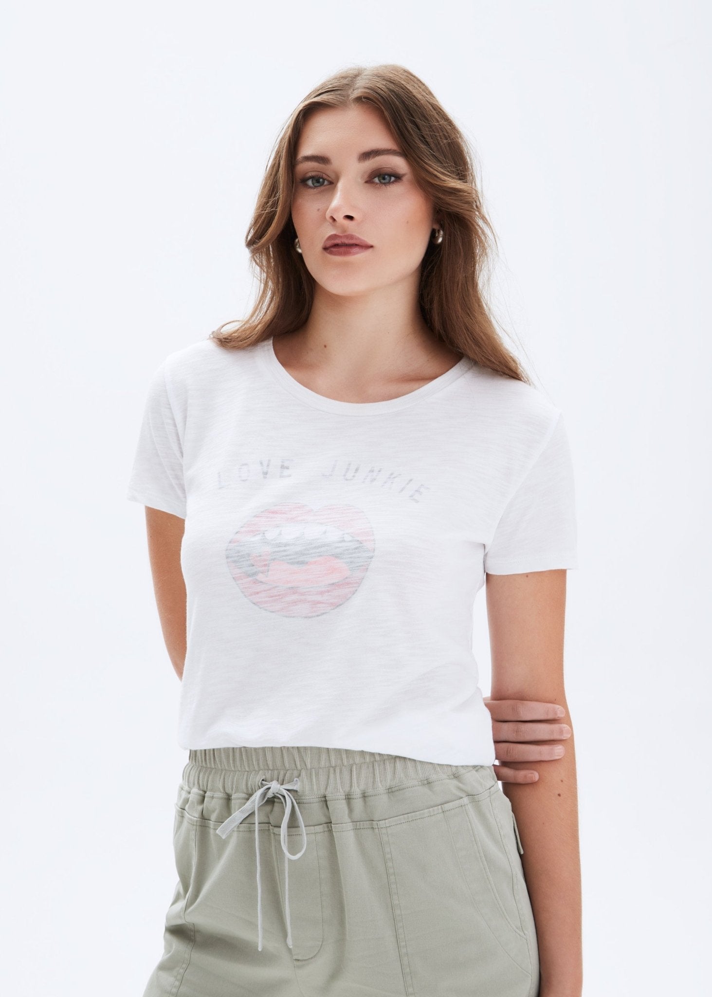 Woman wearing a white t-shirt with a graphic design on a plain background