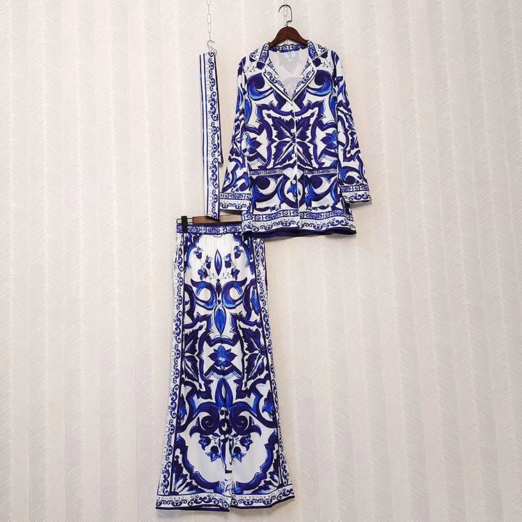 Blue and white patterned outfit on a hanger against a white curtain background