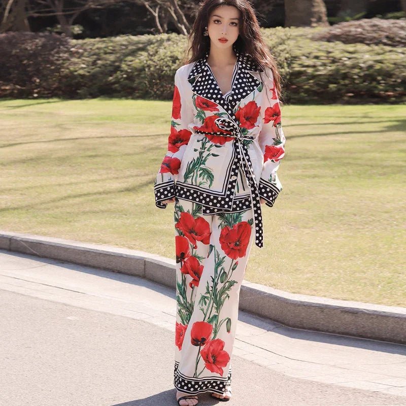 Woman wearing a floral outfit with red flowers and black patterns on a grassy background