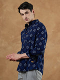 Man wearing a blue patterned shirt against a brown background