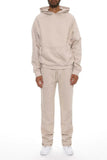 Person wearing a beige tracksuit on a white background