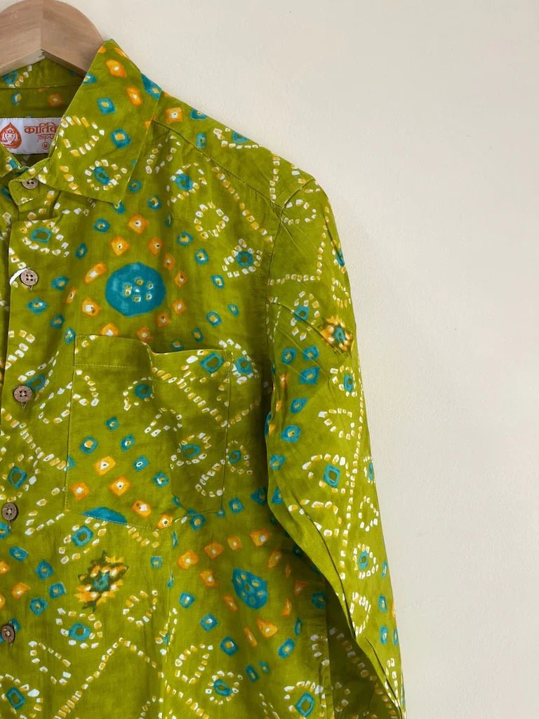 Green patterned shirt on a hanger against a white background