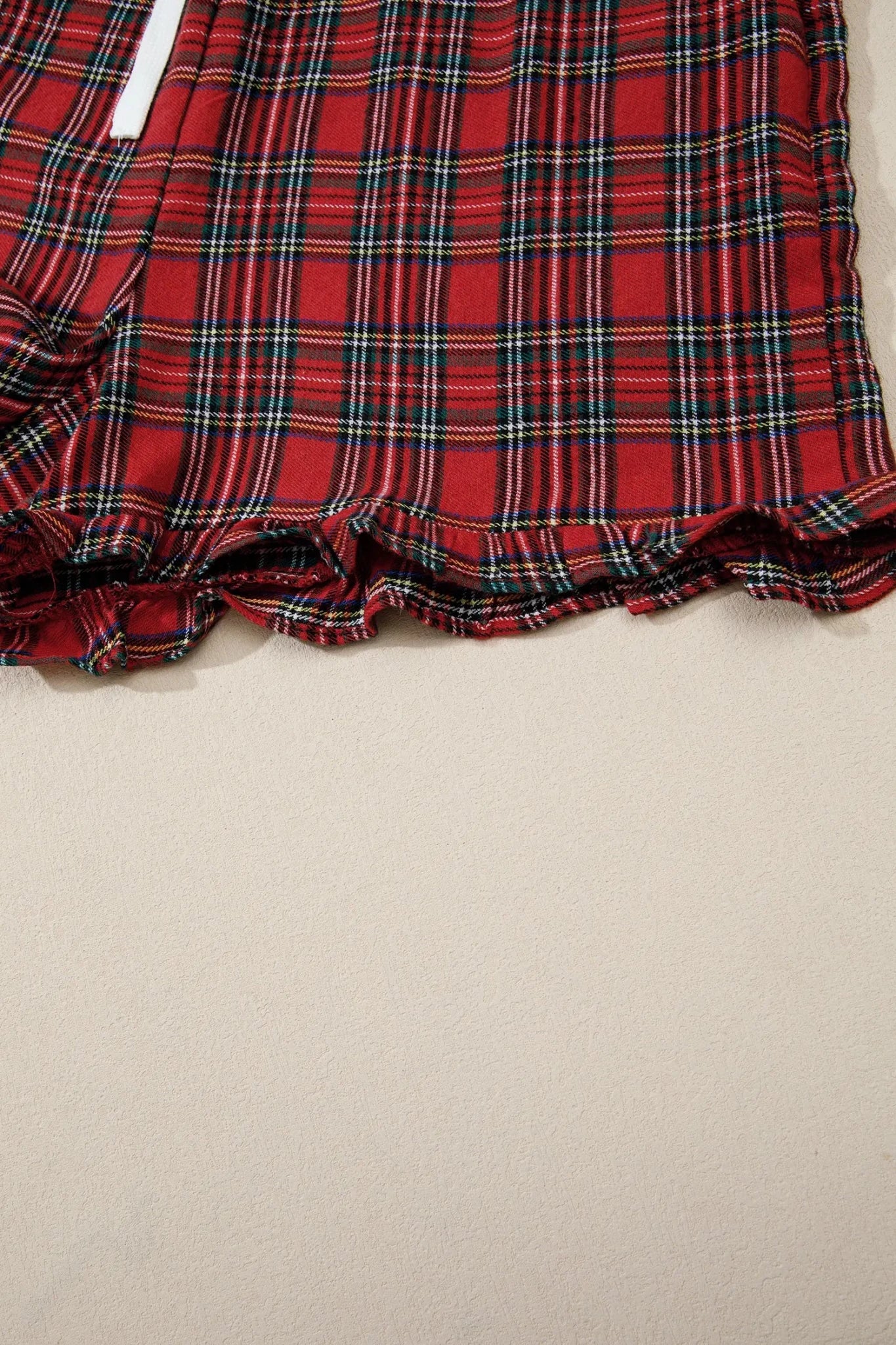Close-up of red tartan plaid garment with a ruffled hem.