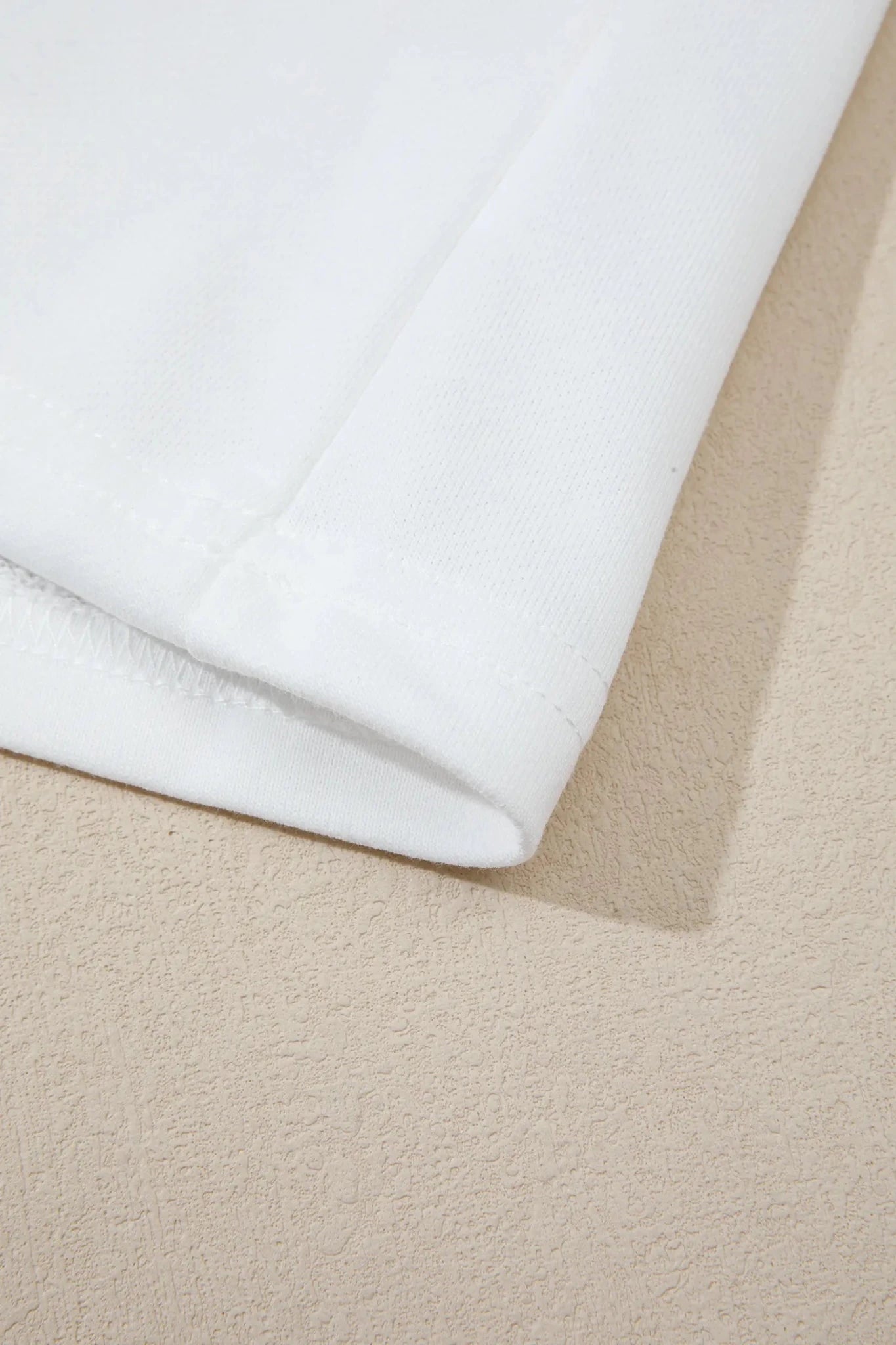 Close-up of folded white fabric showing texture and hem.