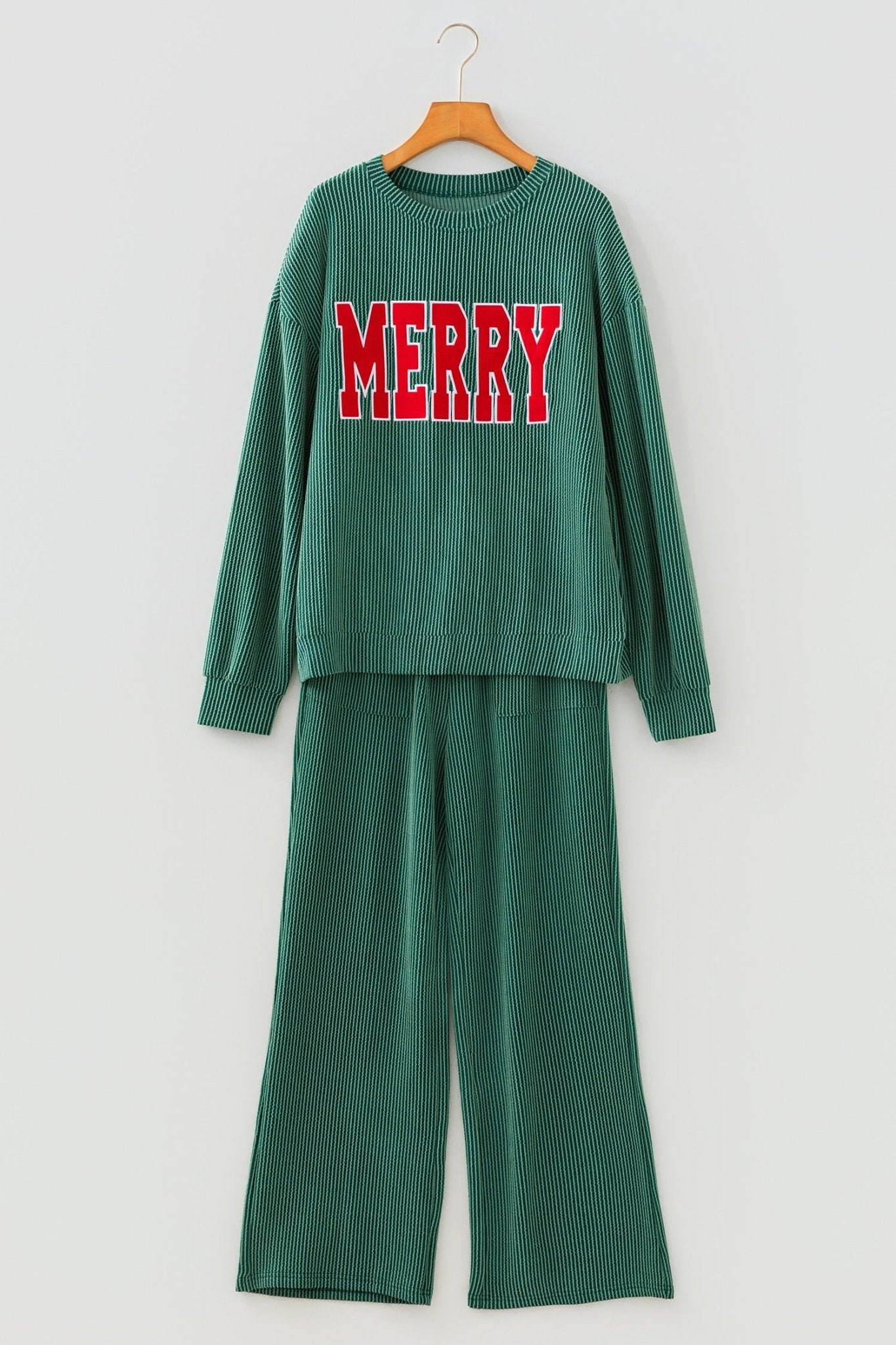 Green outfit with 'MERRY' text on a hanger against a white background