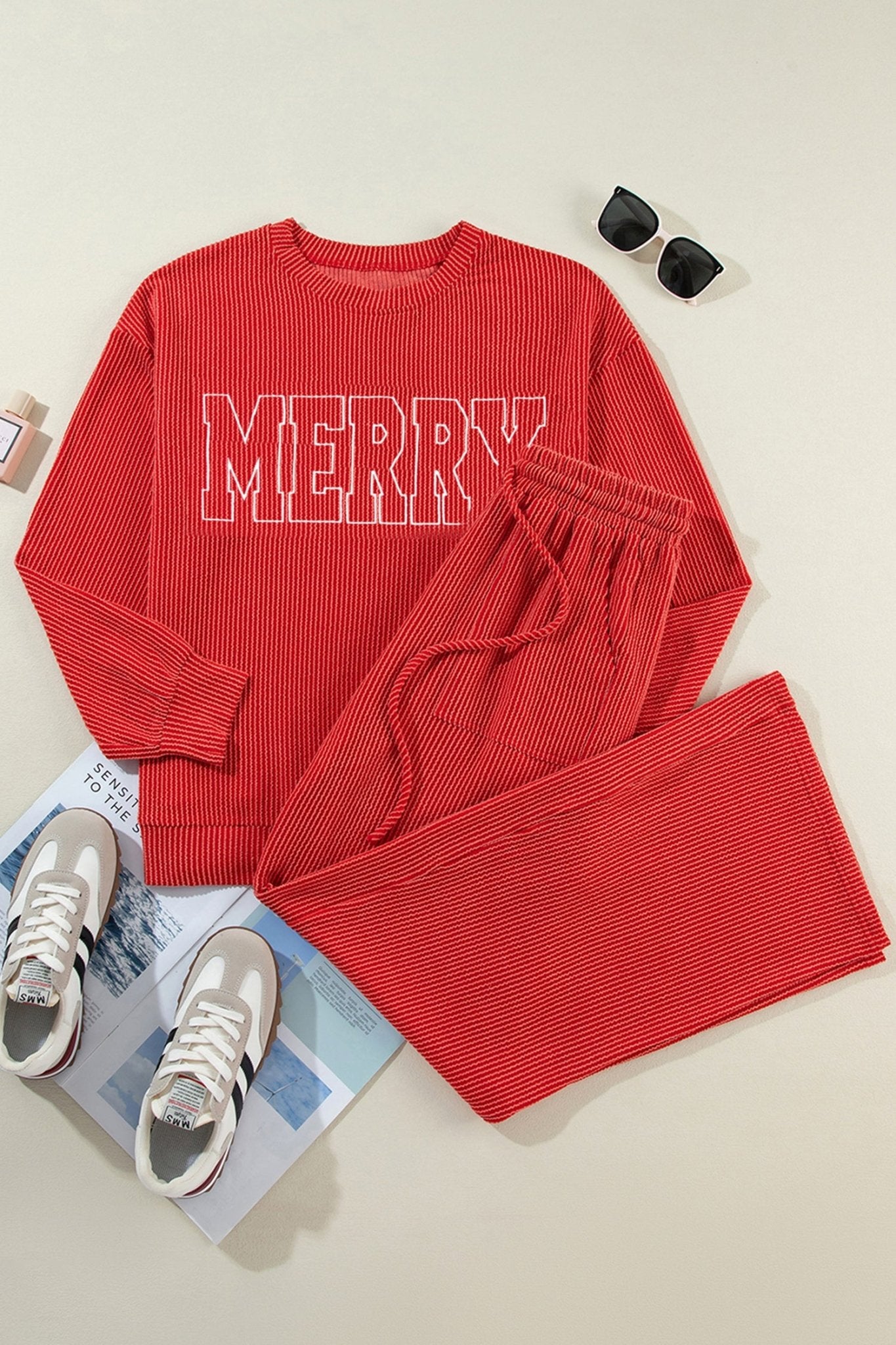 Red ribbed pajama set with outlined “MERRY” text, styled with sunglasses and sneakers.