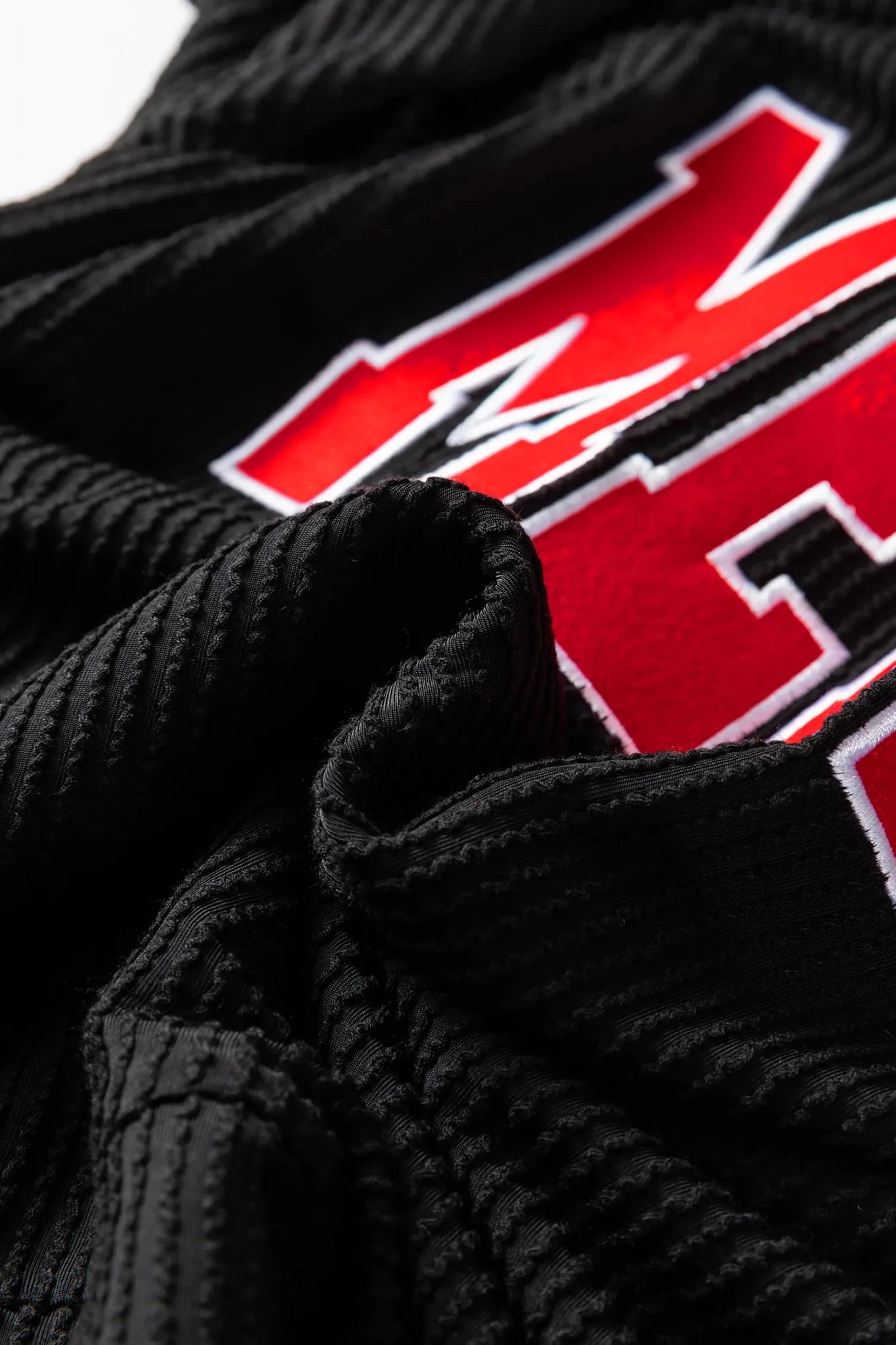 Black jacket with red and white logo on a white background
