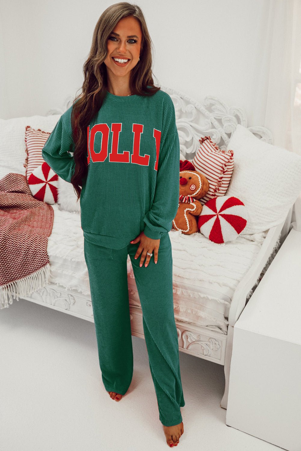 Woman wearing a green 'olly' outfit in a cozy living room setting.
