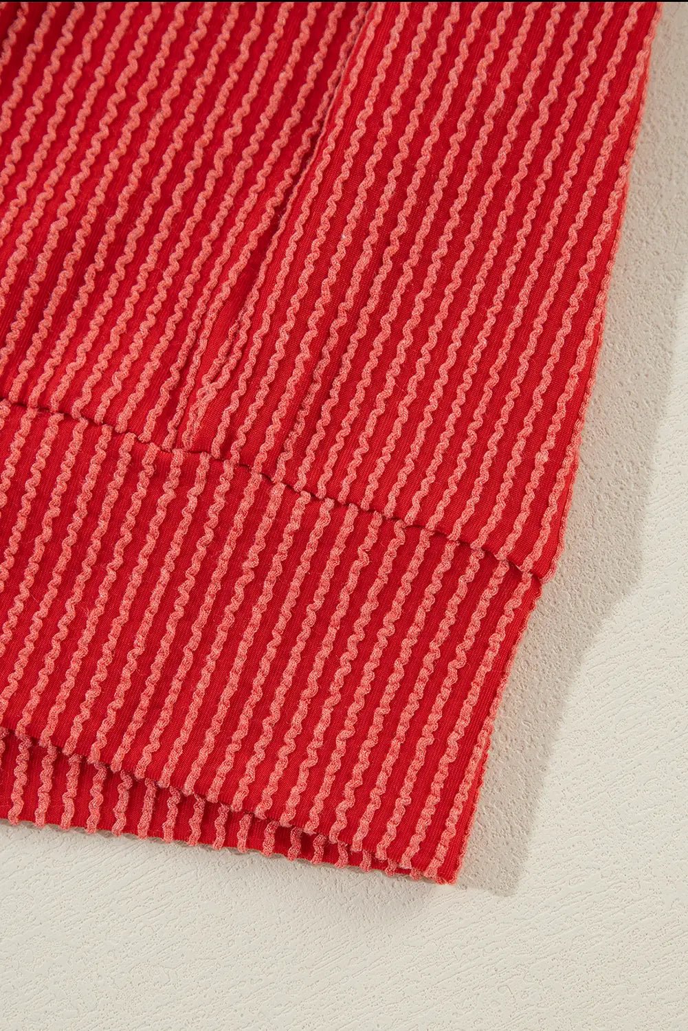 Close-up of a red textured fabric on a beige background