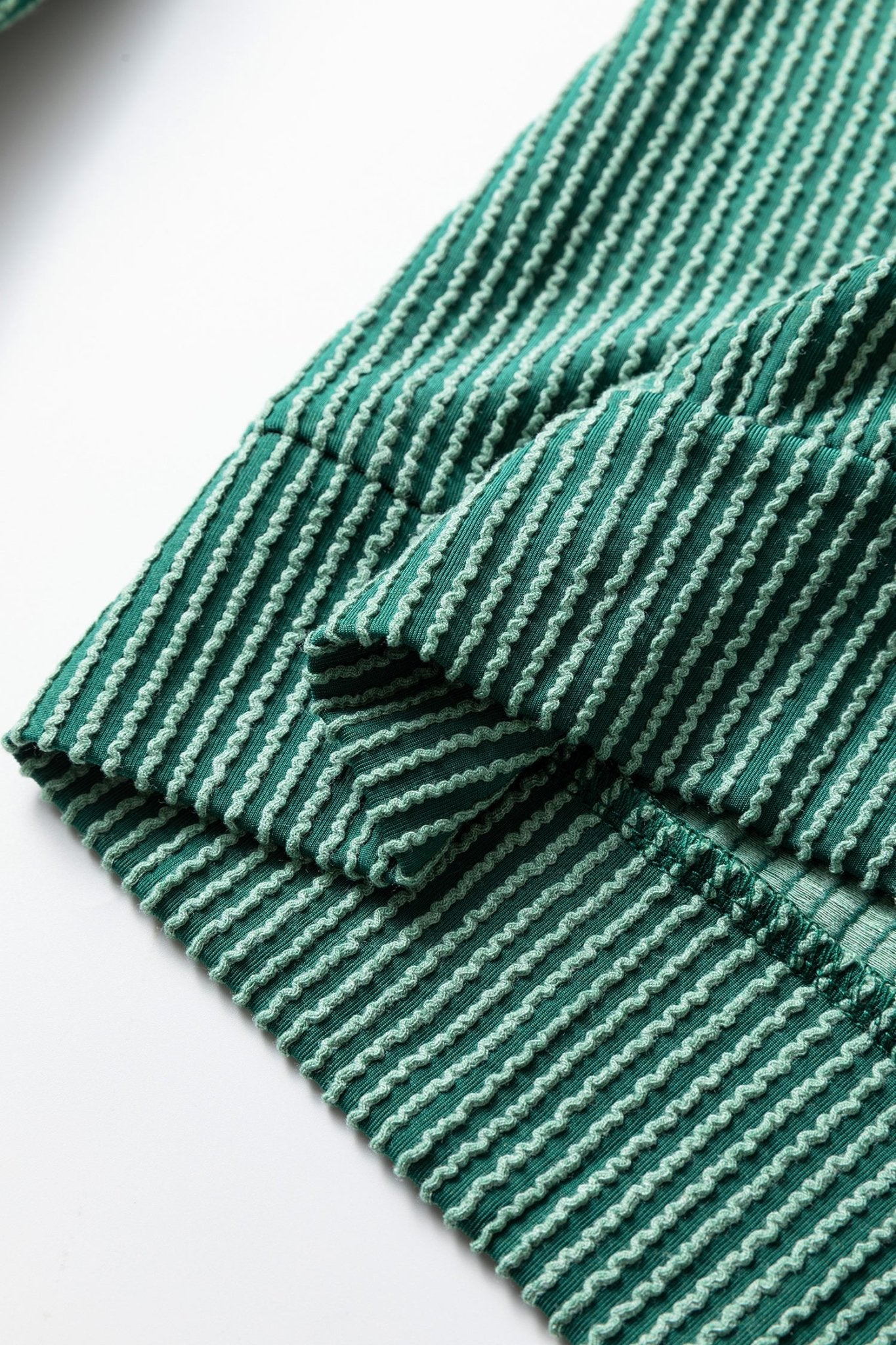 Close-up of green striped fabric with a white background