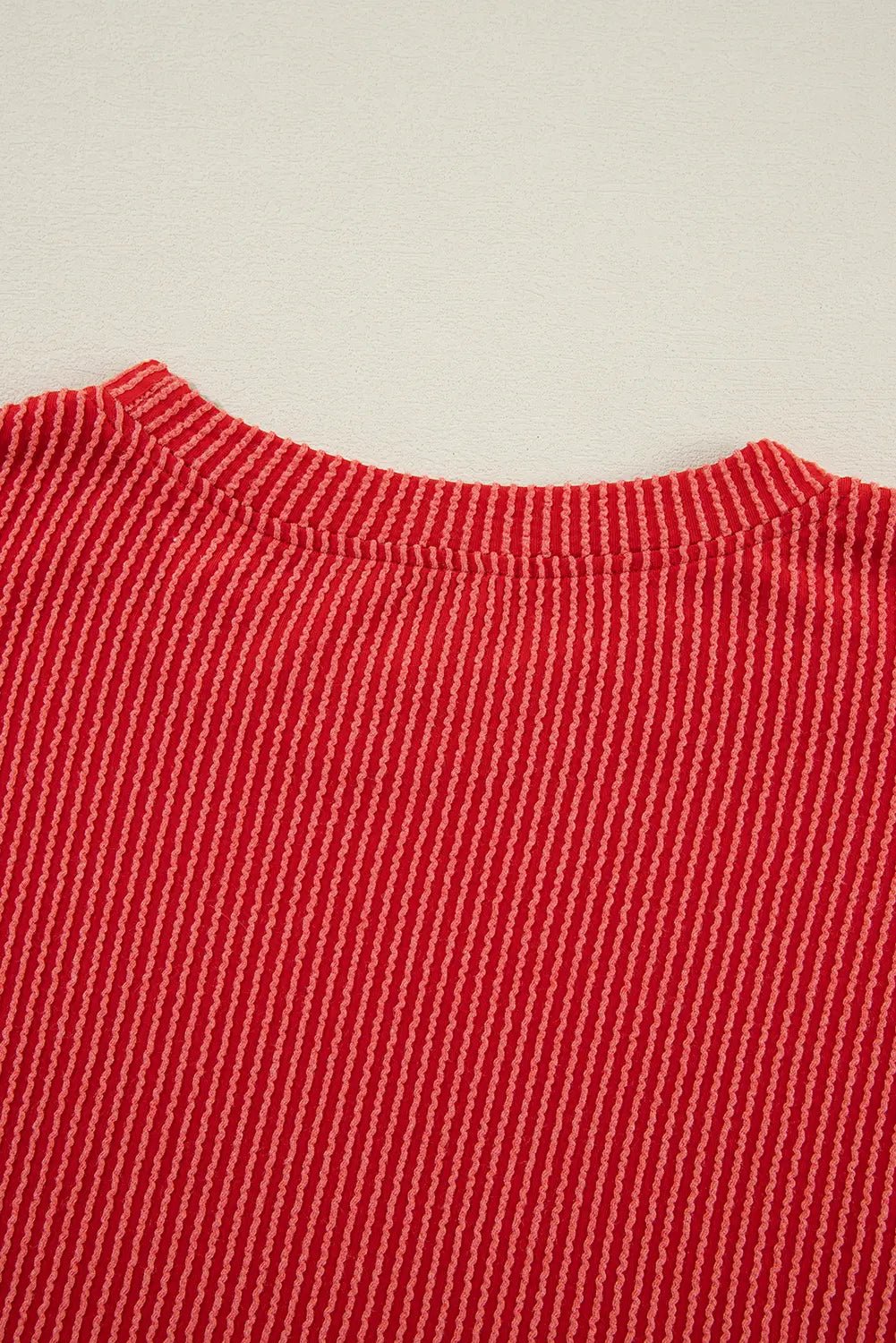 Red knit fabric with fine white stripes and a visible collar.