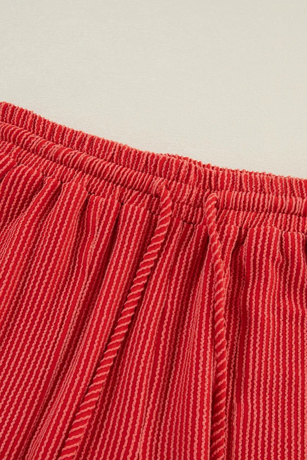 Red pleated garment with thin white stripes and elastic waistband.