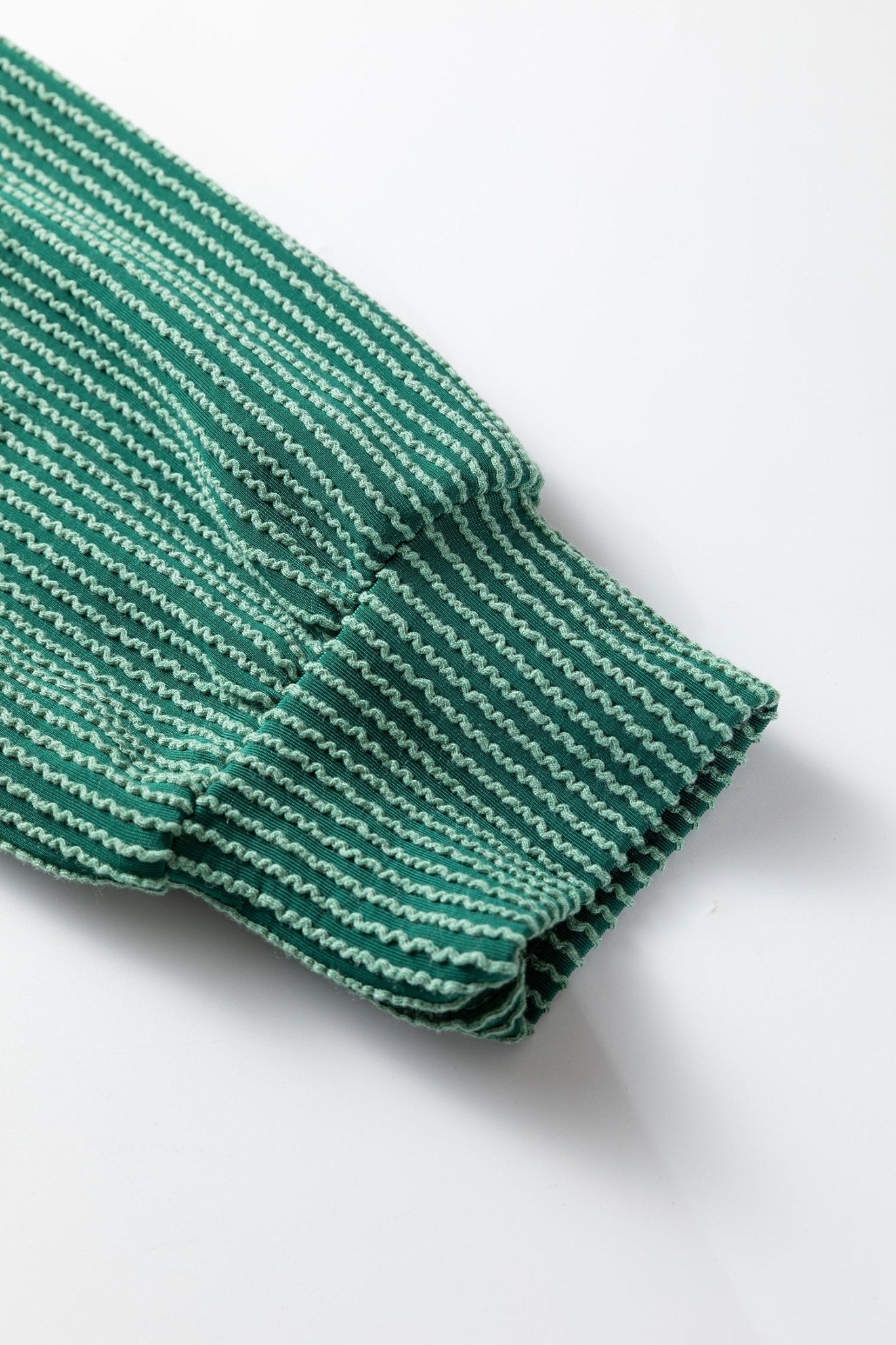 Green and white striped fabric on a white background