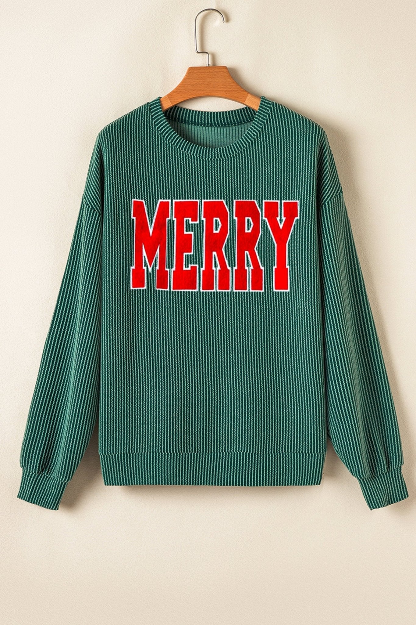 Green sweater with 'MERRY' in red on a beige background