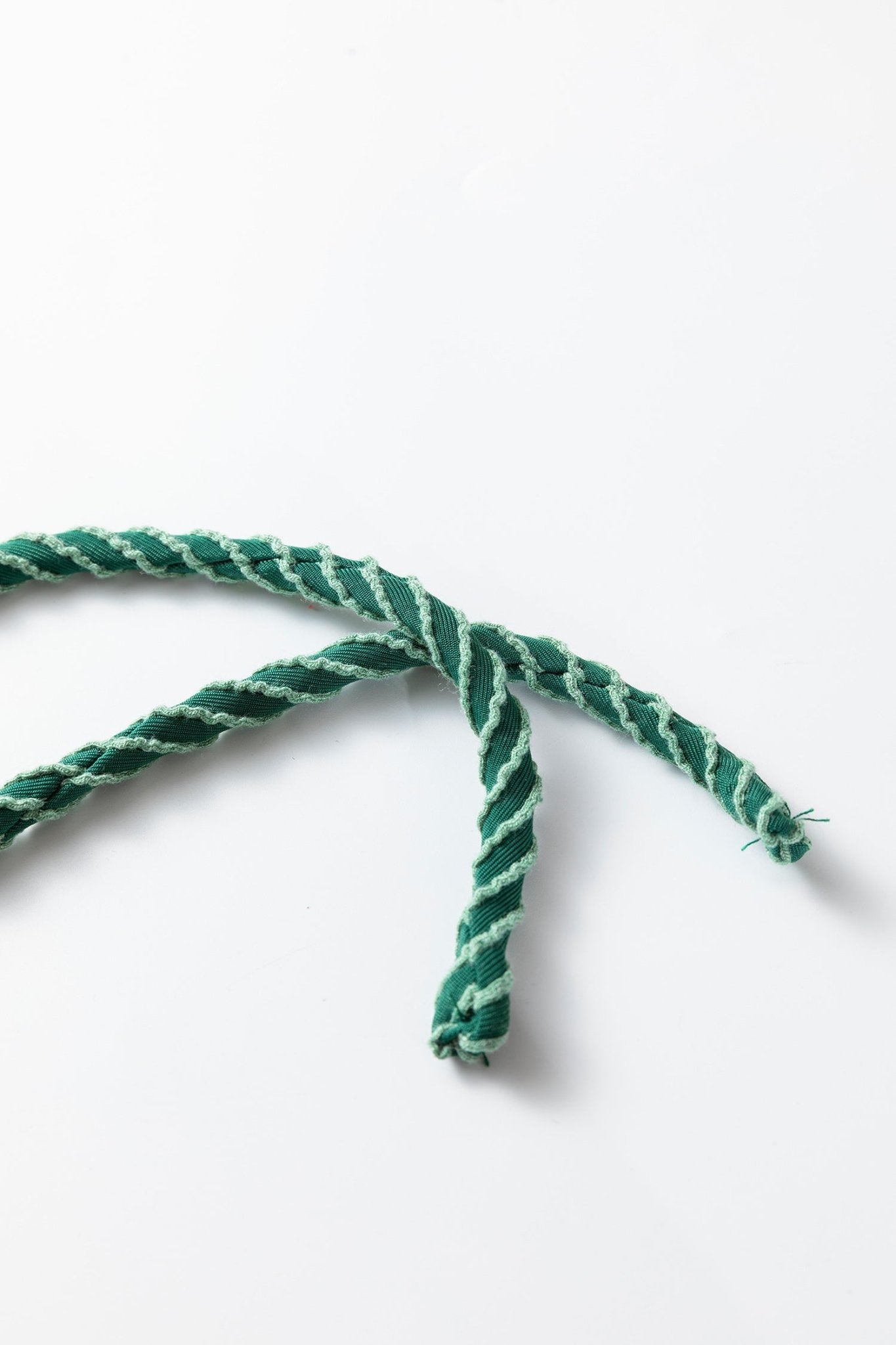 Green and white braided rope on a white background