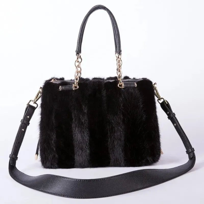 Black fur handbag with gold accents on a white background