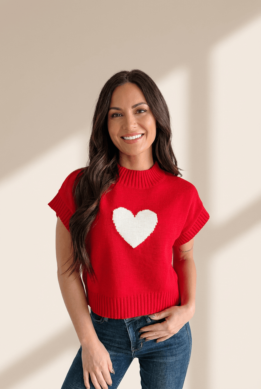 Woman wearing a red sweater with a white heart design against a beige background