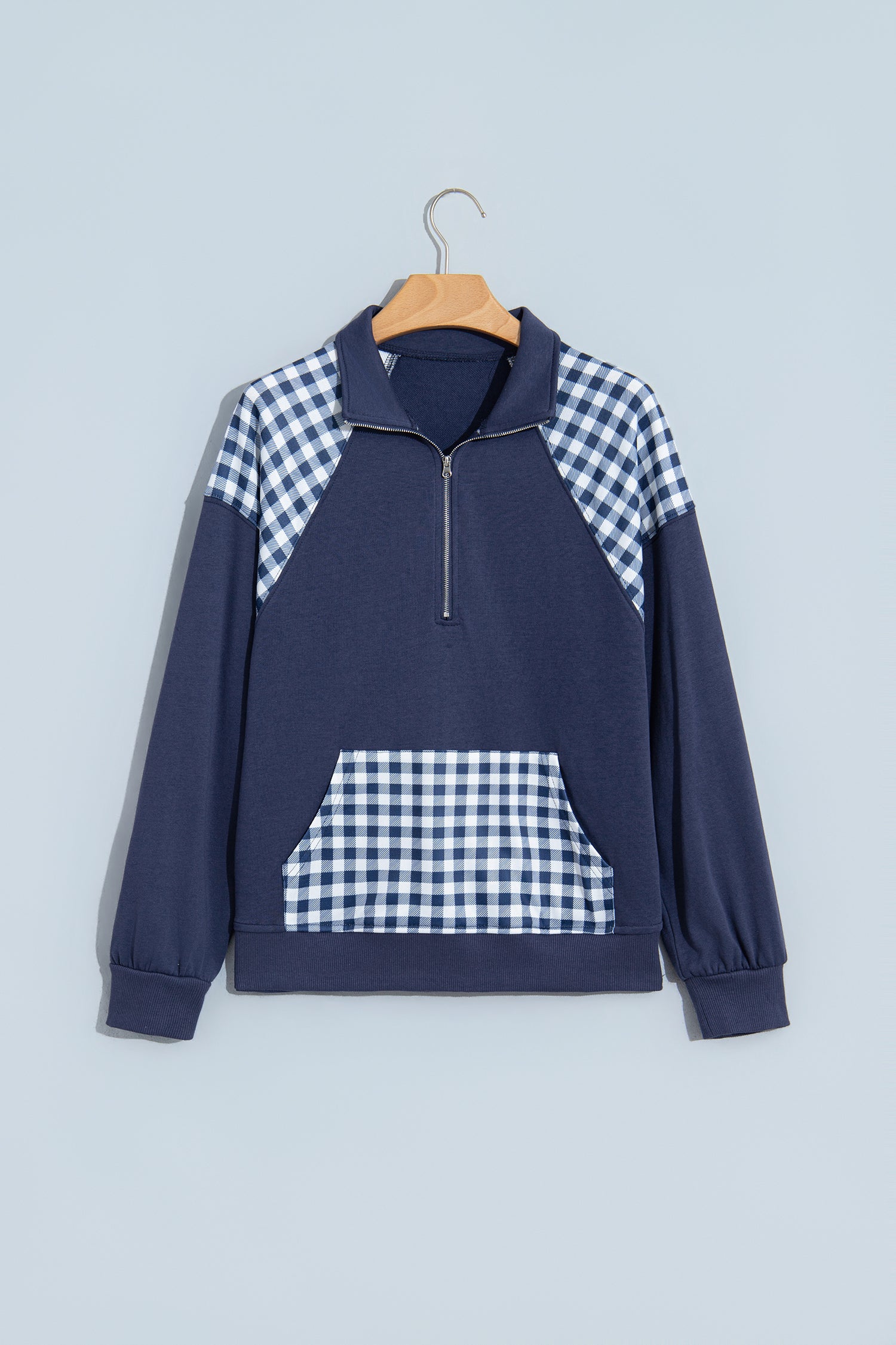 Navy blue plaid quarter zip sweatshirt on hanger, front view