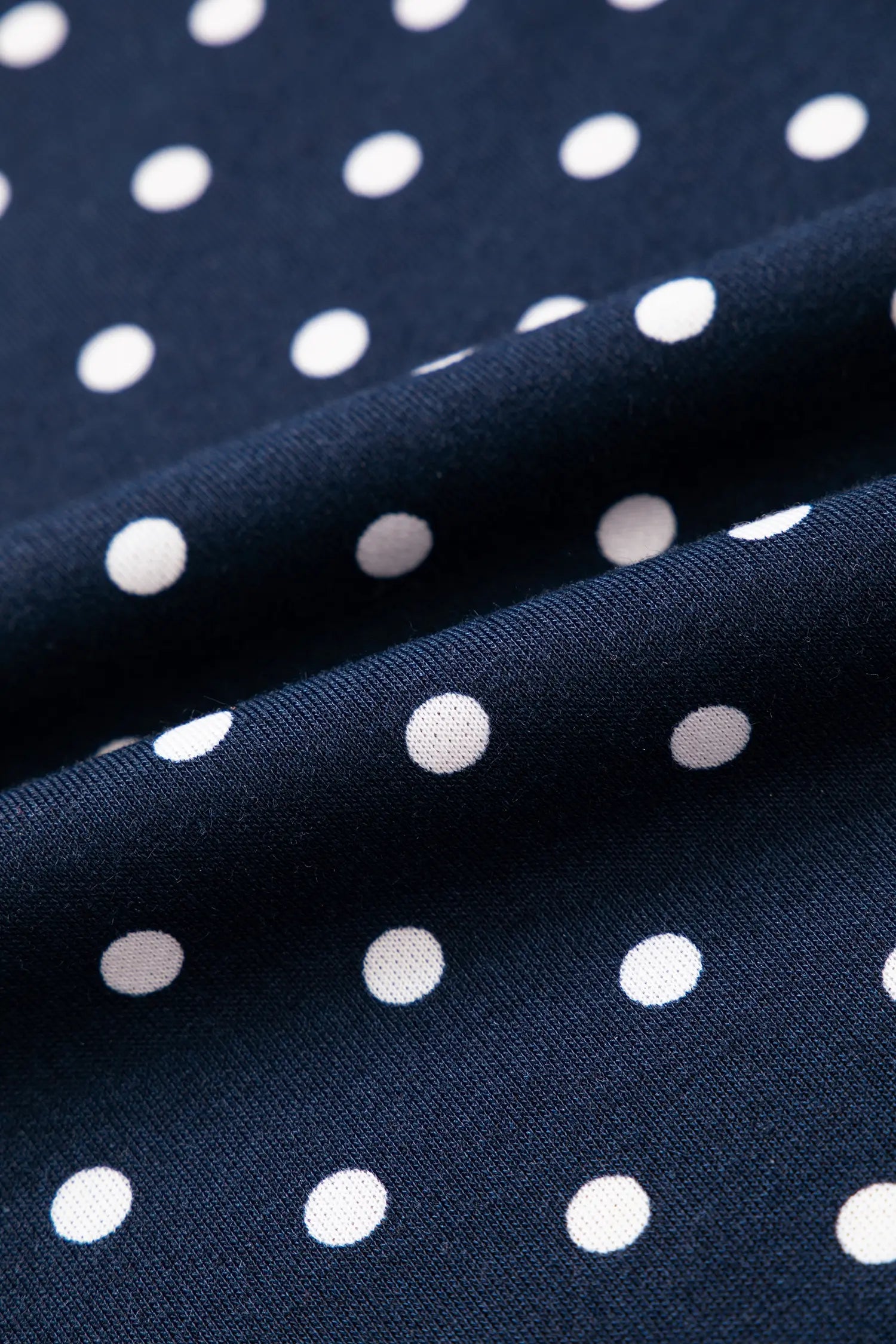 Close up of soft navy polka dot knit fabric