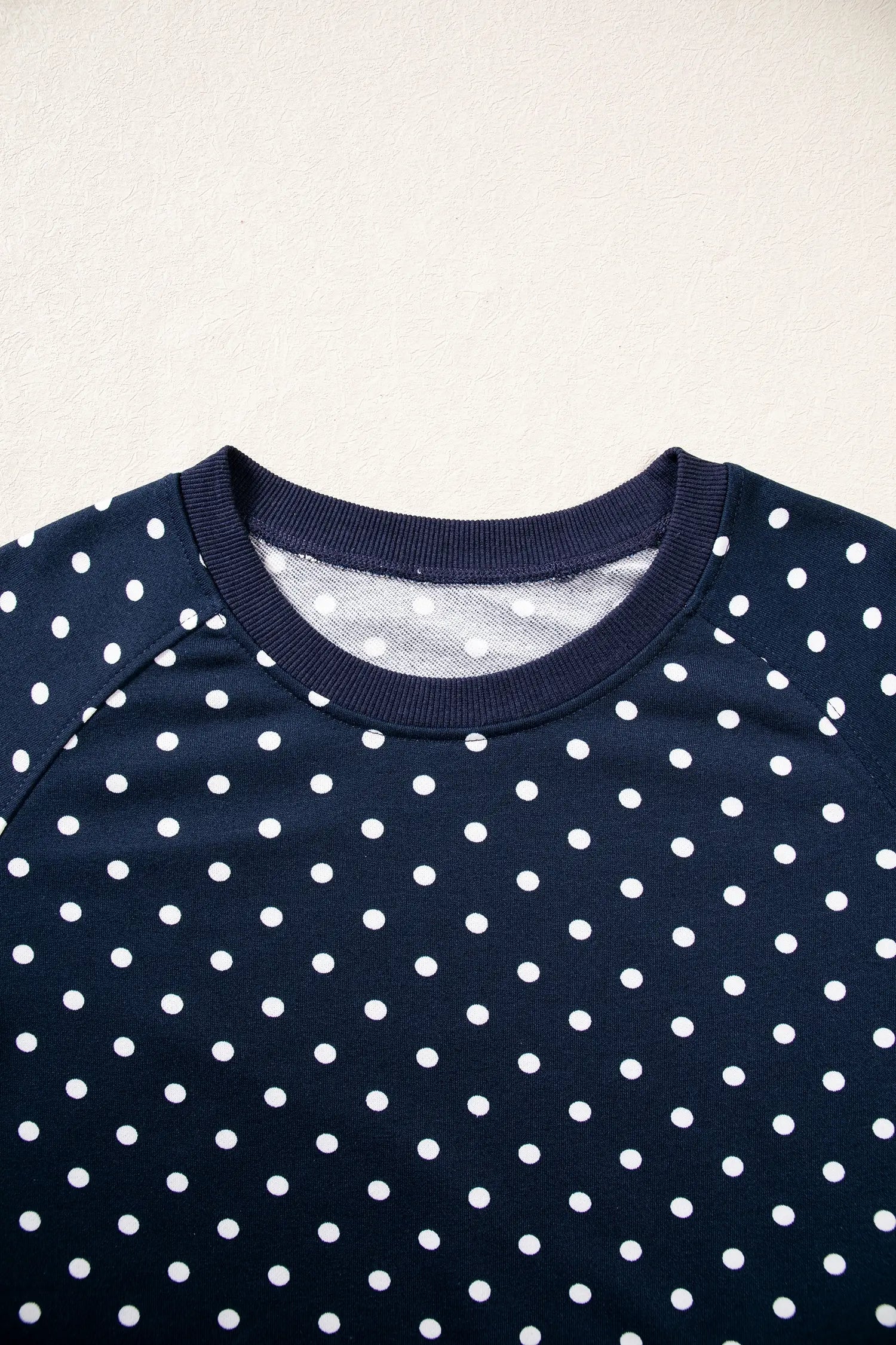 Ribbed crew neck and raglan seams on the navy polka dot top