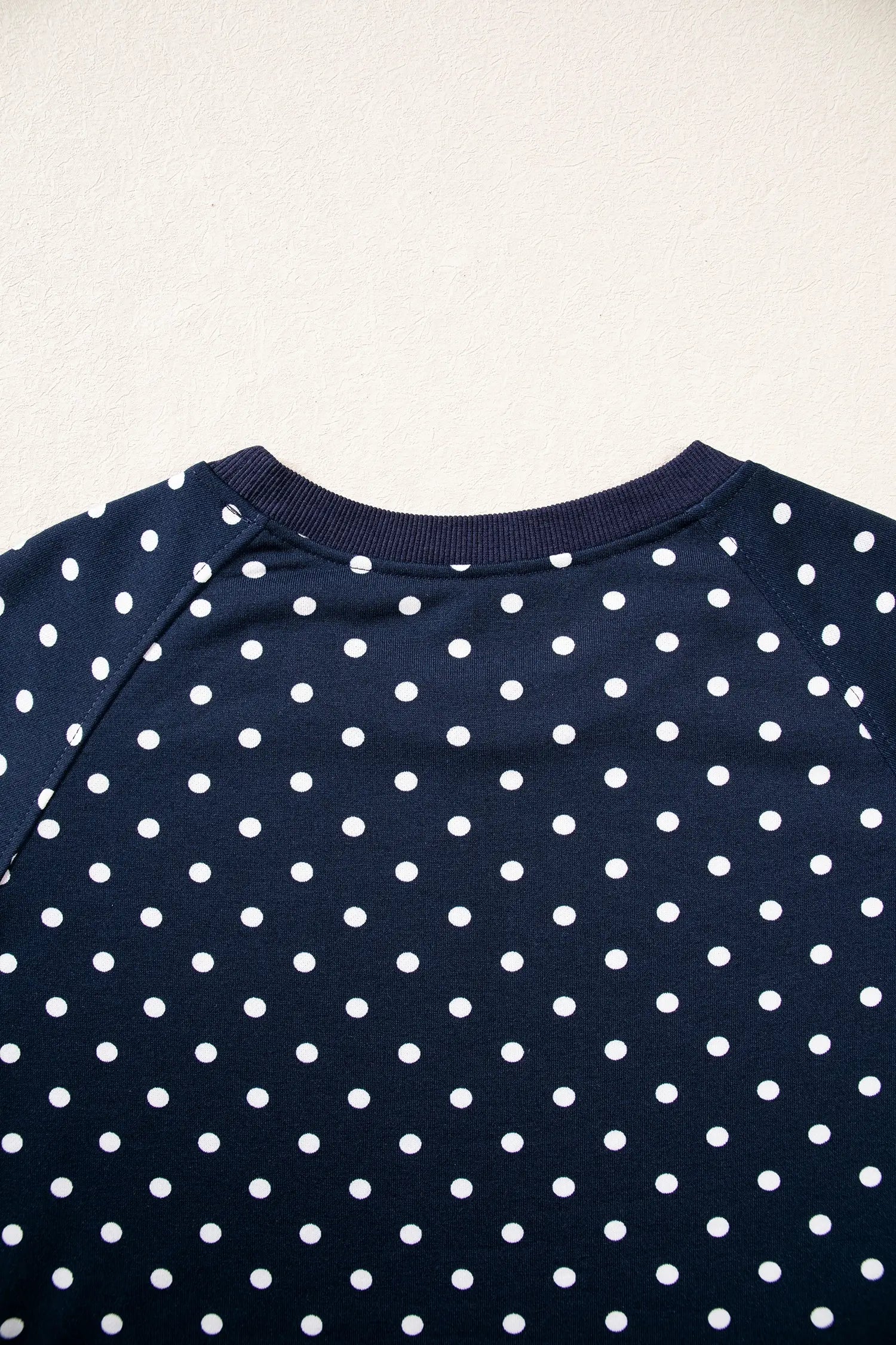 Close up of the navy polka dot top neckline with ribbed trim