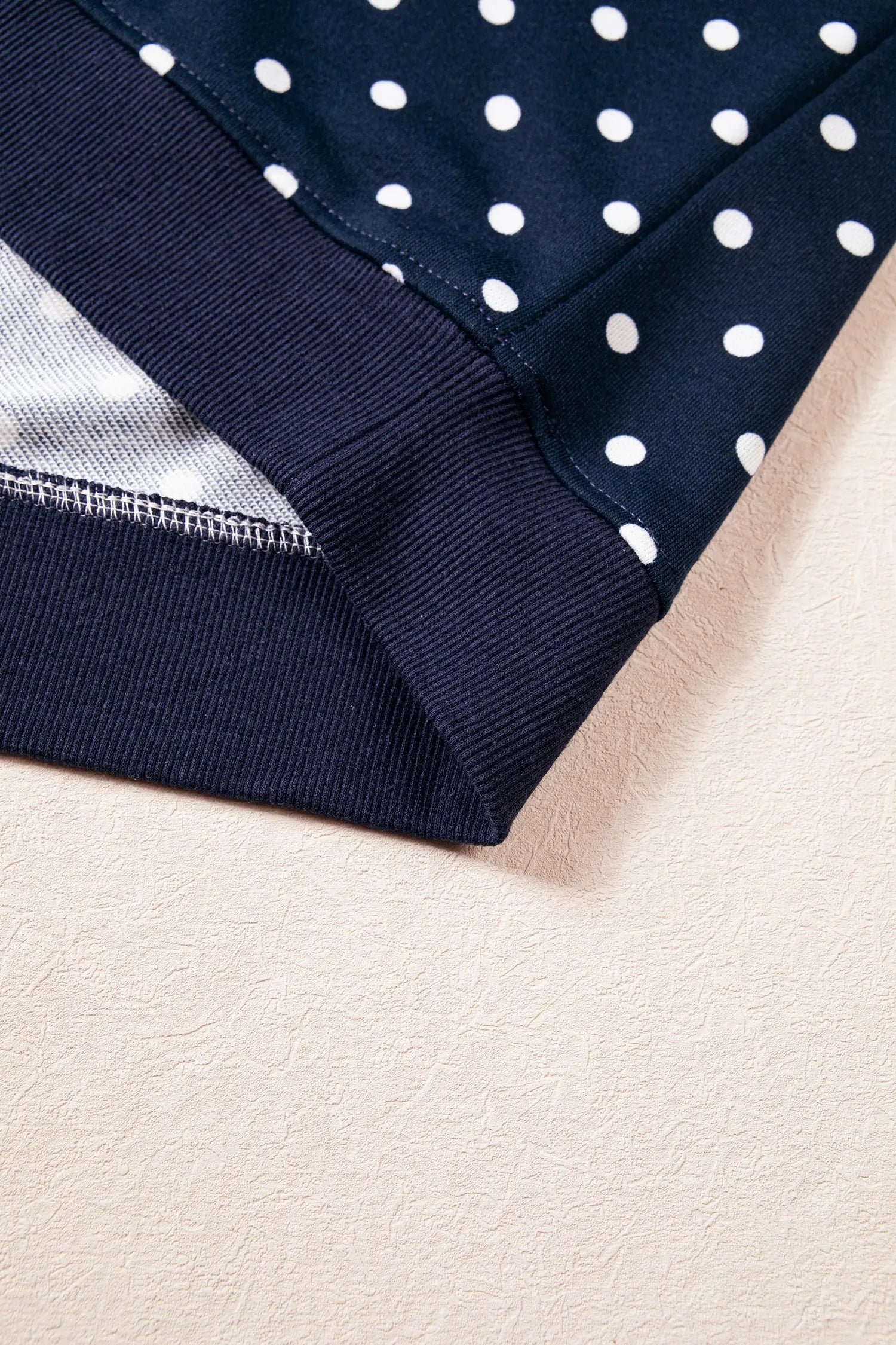 Ribbed hem band detail on the navy polka dot top