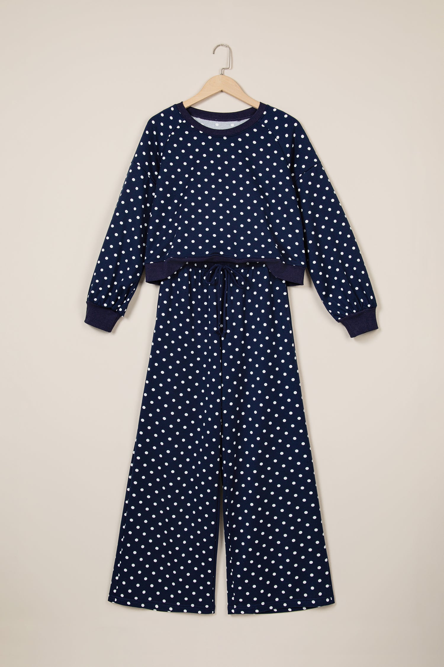 Navy polka dot top and wide leg pant set on a hanger, front view
