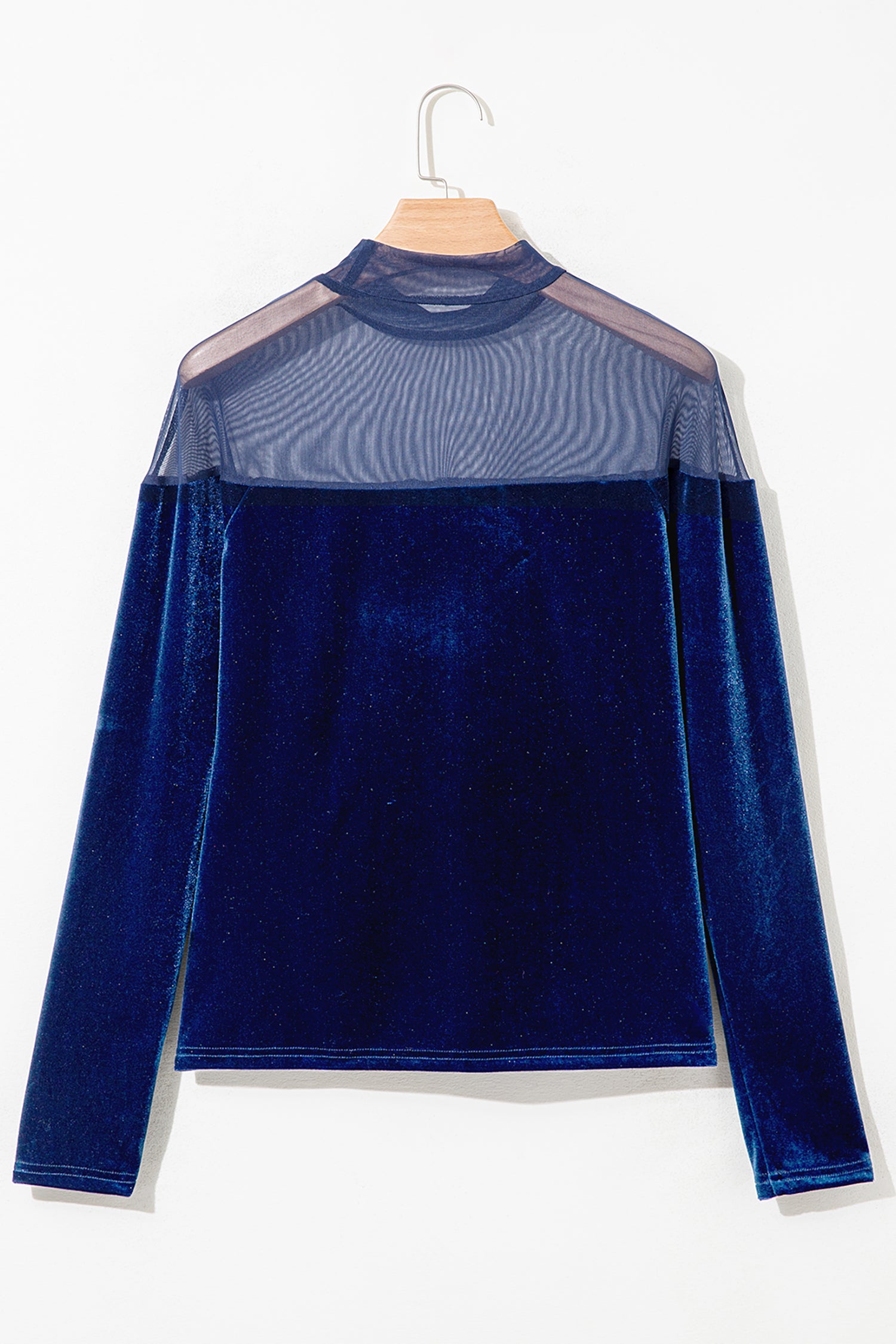 Navy velvet long sleeve top with sheer mesh yoke on a hanger, back view