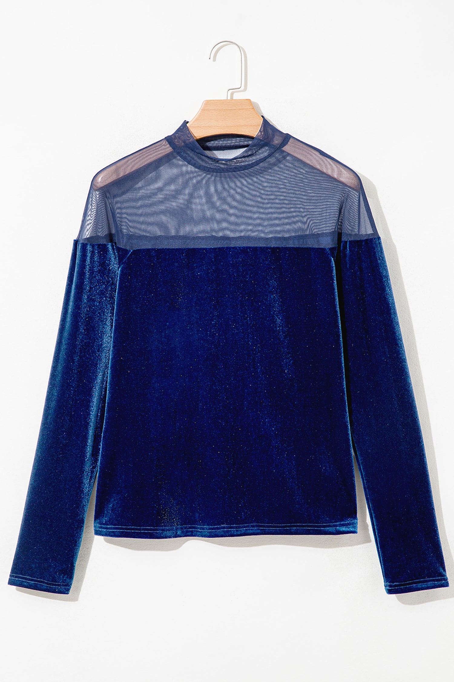 Navy velvet long sleeve top with sheer mesh yoke on a hanger, front view