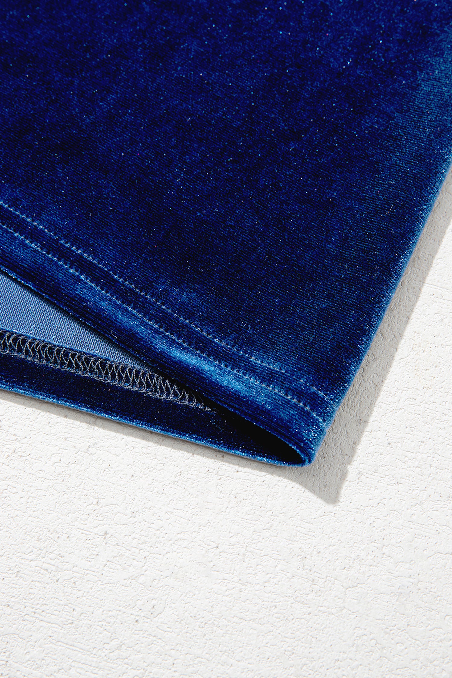 Hem detail on navy stretch velvet long sleeve top