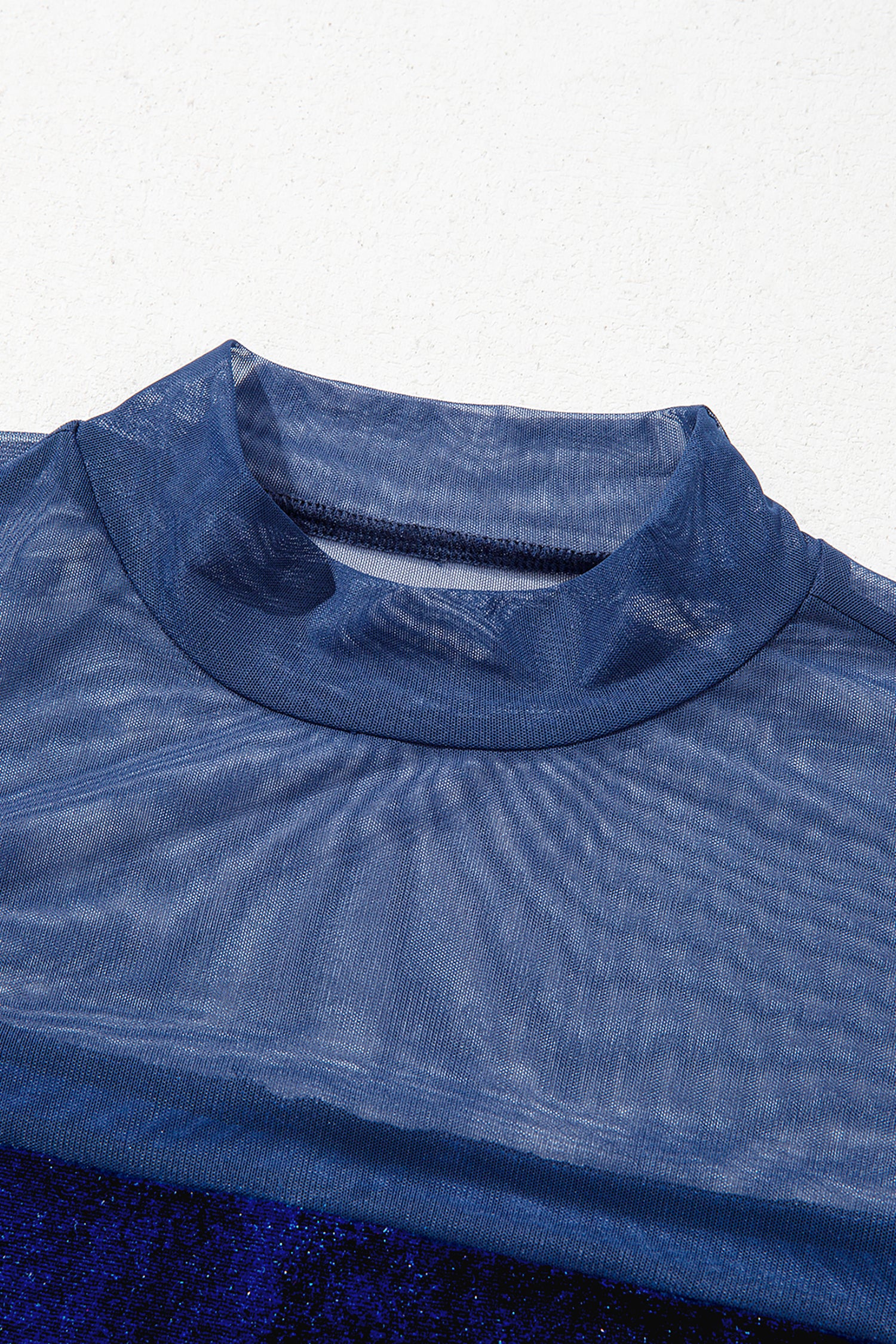 Close-up of sheer navy mesh mock neck on velvet long sleeve top