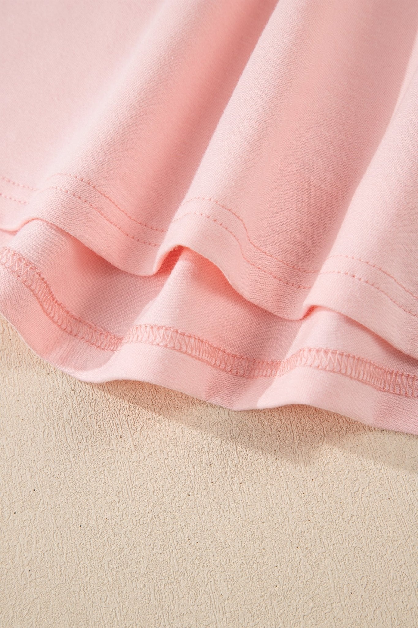 Close-up of a pink fabric texture on a beige background