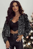 Woman wearing a black sequin jacket over a black top and leather pants in front of a Christmas tree.