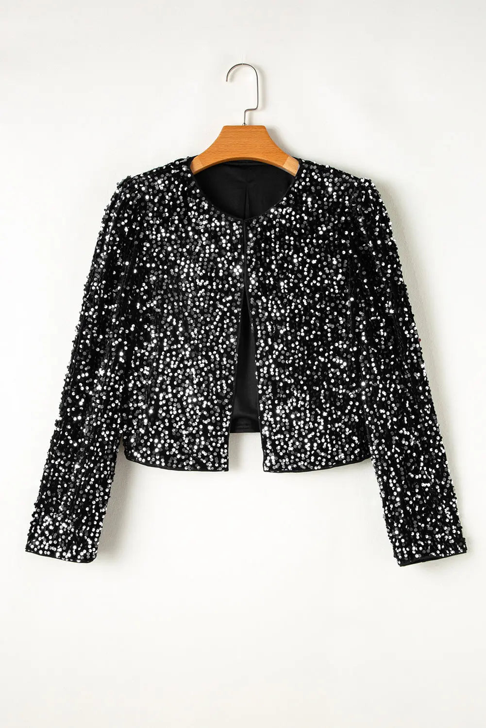Black sequin jacket on a hanger against a white background