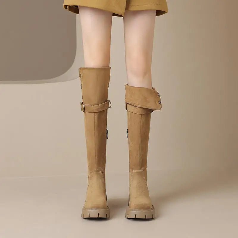 Tan knee-high boots worn with a mustard skirt on a neutral background