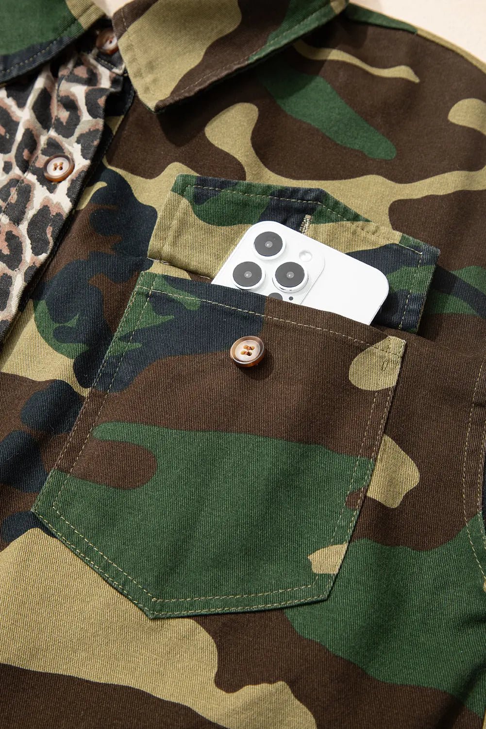 Camouflage jacket with a pocket containing a smartphone