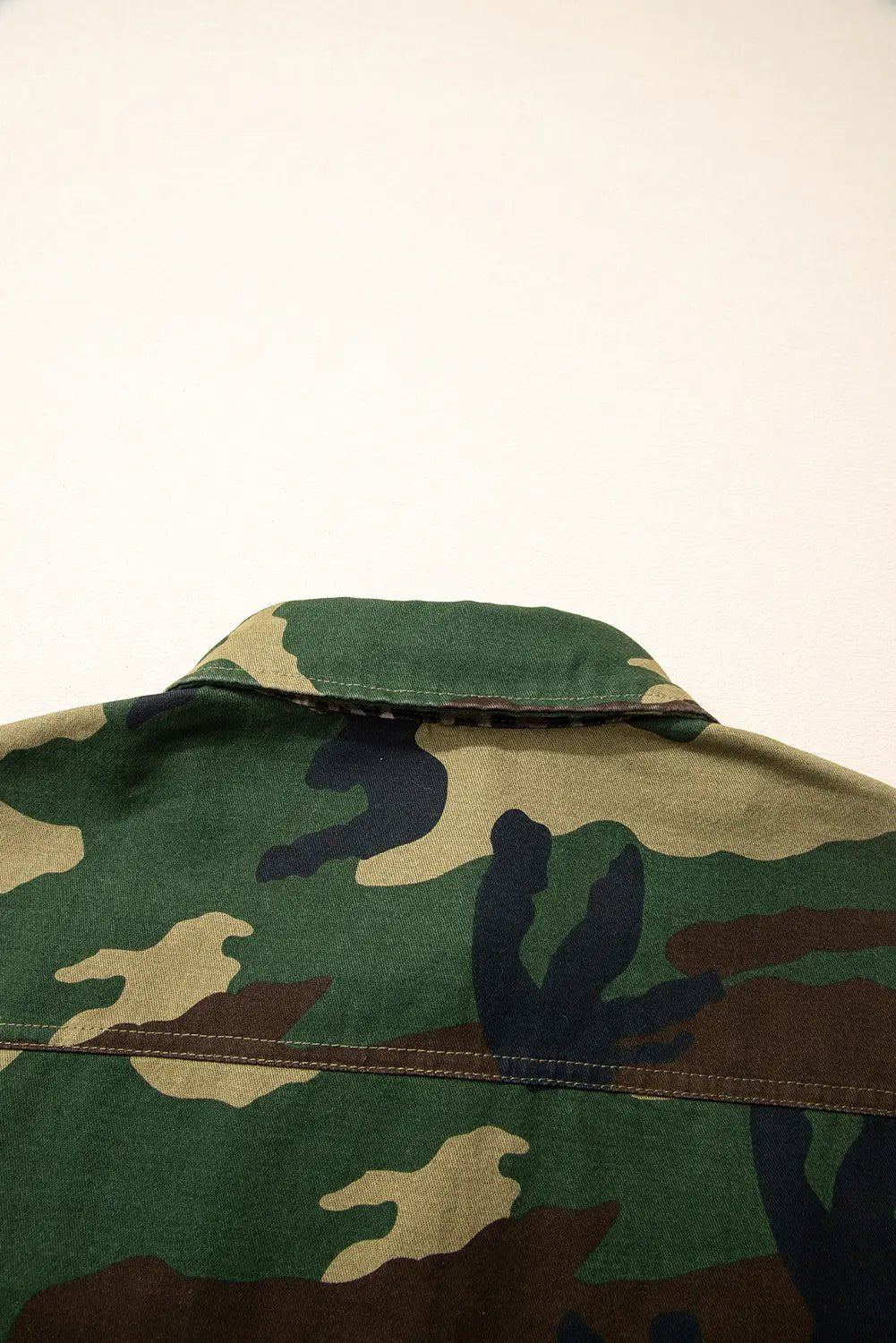 Camouflage jacket on a light beige background