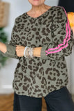 Person wearing a leopard print top with pink trim in an indoor setting