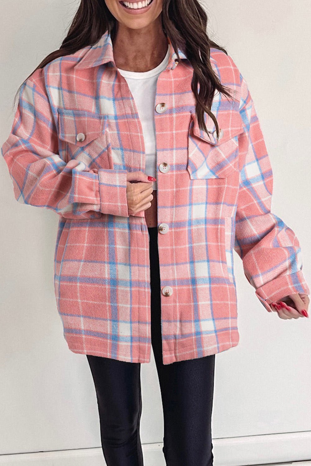 Person wearing a pink and blue plaid jacket against a white background