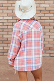 Person wearing a red and white plaid shirt with a white hat against a brick wall.