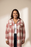 Woman wearing a plaid shirt against a plain background