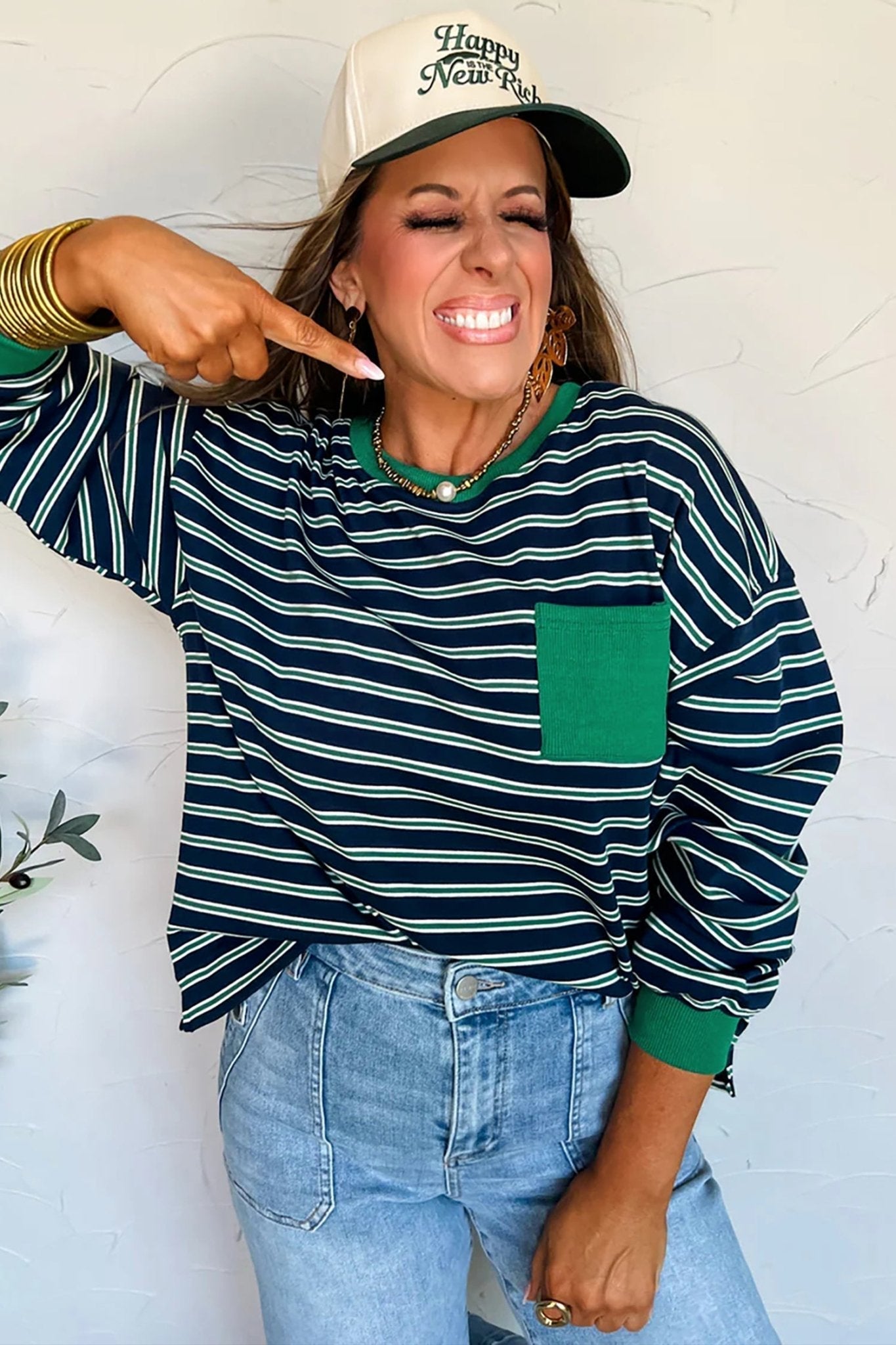 Woman wearing a striped sweater and cap with a neutral background